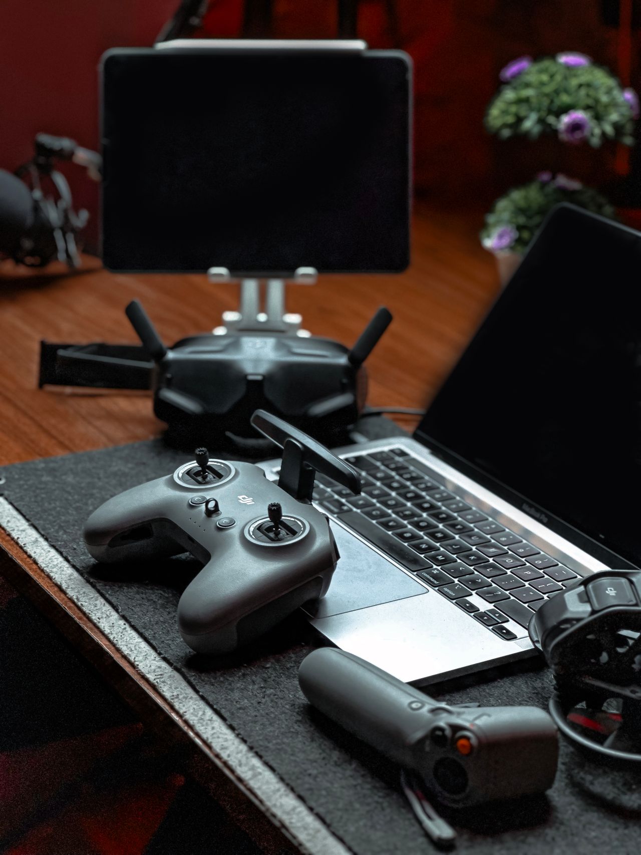 A drone controller set up beside a laptop and tablet