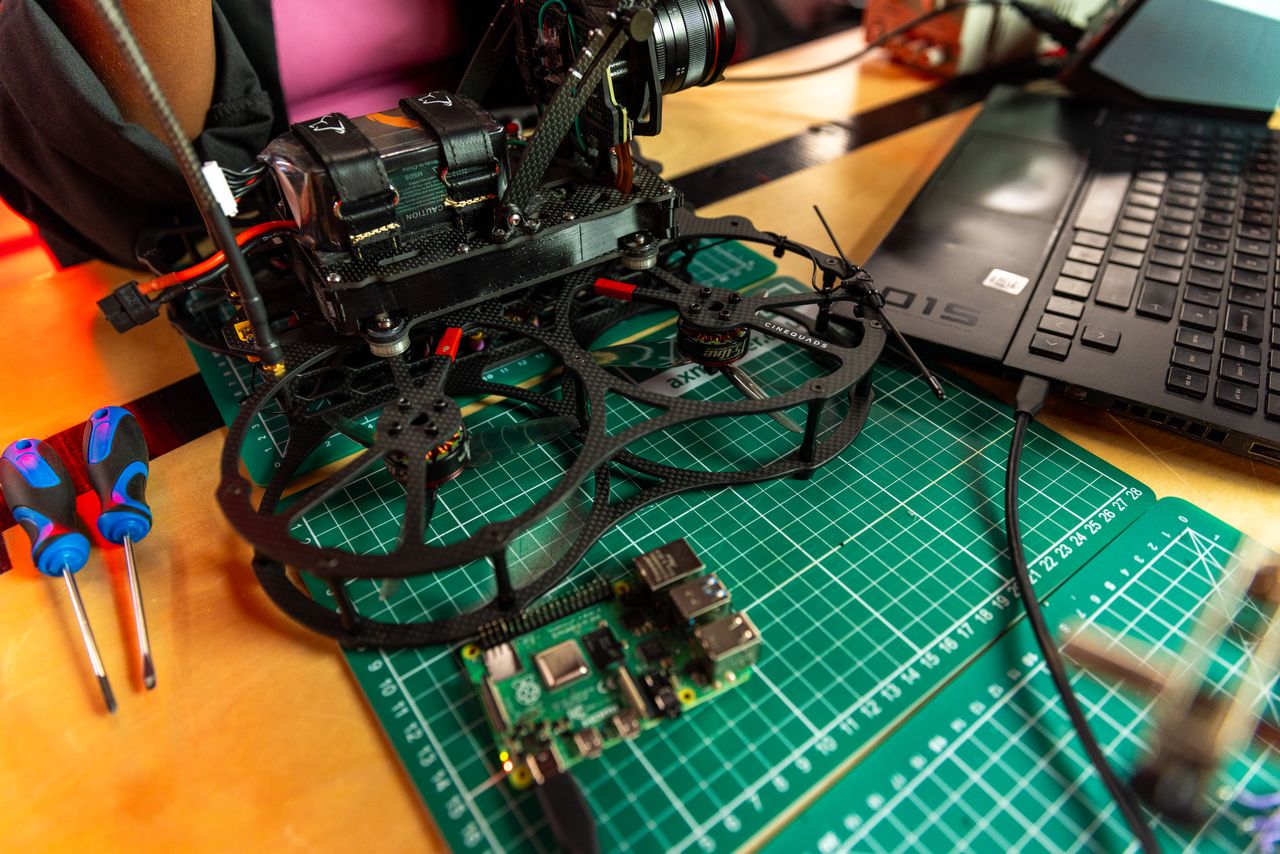A drone being assembled at a desk with a laptop