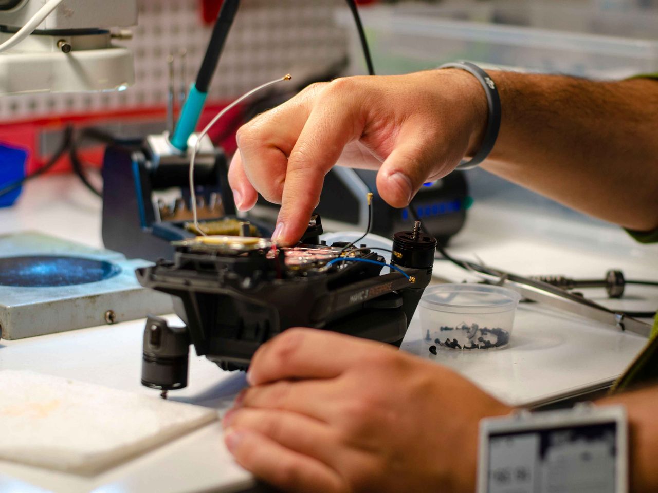A technician repairing a drone on a workbench